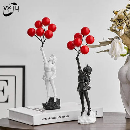 Two resin balloon girl graffiti statues in black and white holding red balloons for modern living room decor