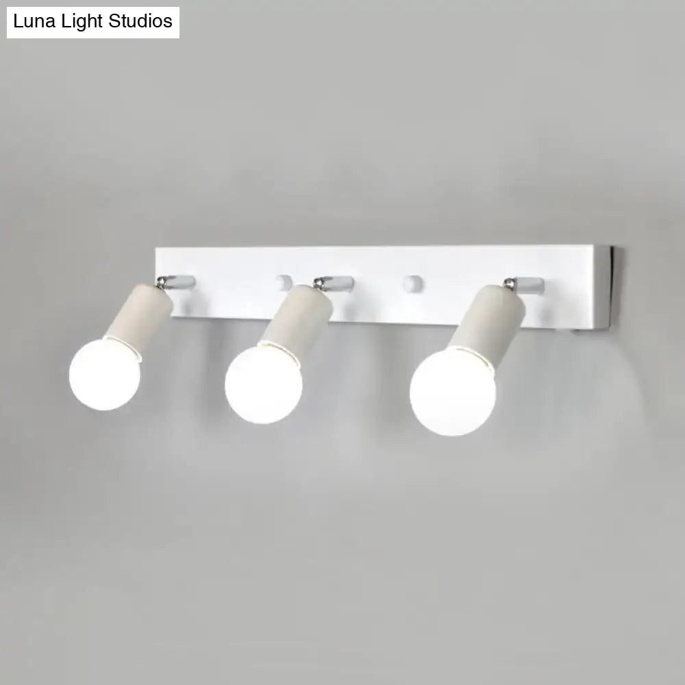 Modern black and white bedroom vanity light with three adjustable exposed bulb spotlights wall-mounted fixture