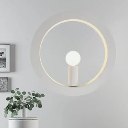 Minimalist modern black and white circle wall light with warm glowing ring and white cylindrical base for bedroom use