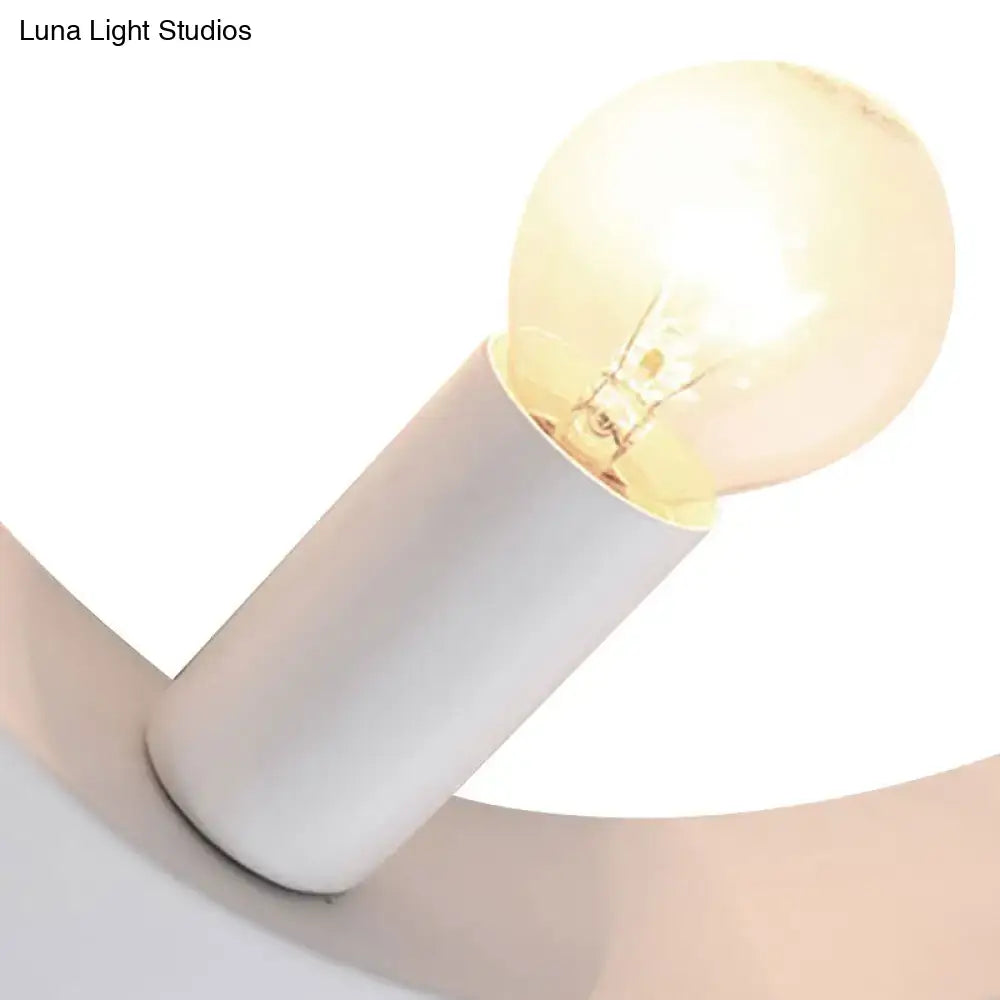 A warm glowing filament bulb with frosted glass globe on a sleek white circle wall lamp base for bedroom use