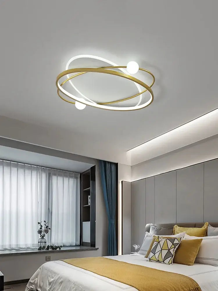Modern gold-toned circular decorbites led ceiling light with intertwined rings and three white bulbs for living room use