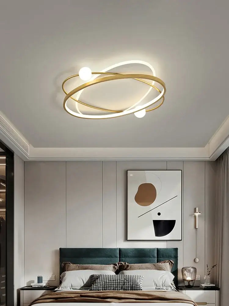 Modern gold-toned decorbites led ceiling light with intertwined rings and three spherical bulbs for living room use