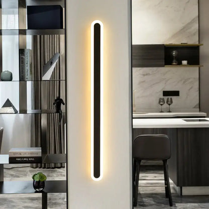 Modern black elliptical acrylic wall sconce with a glowing warm white led light strip for aisle lighting