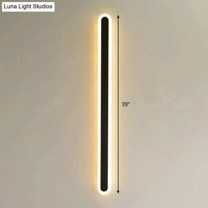 A sleek 39-inch tall modern black elliptical acrylic wall sconce with glowing white led edge lighting flush mount