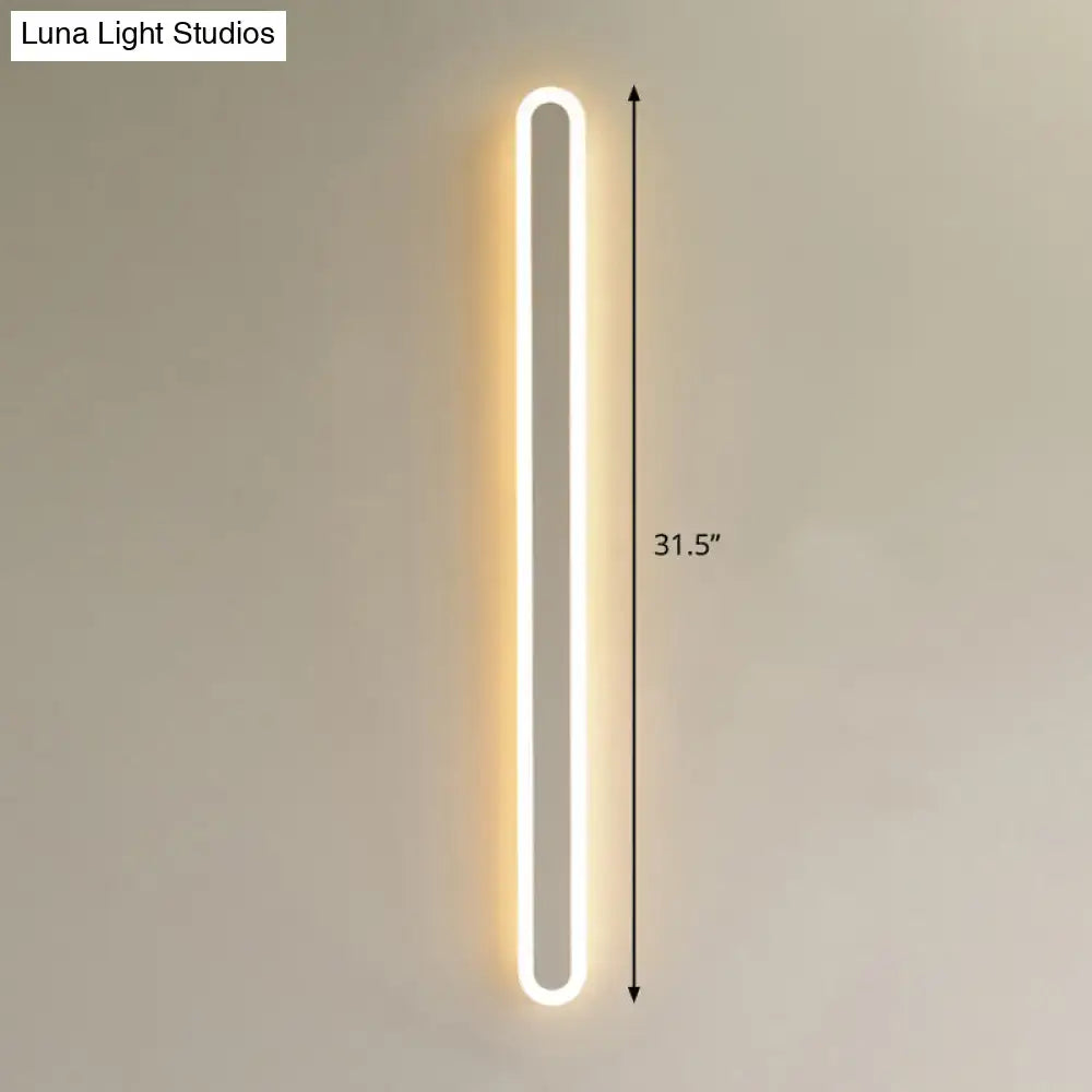 A sleek modern black and white elliptical acrylic flush wall sconce emitting warm white light for aisle lighting