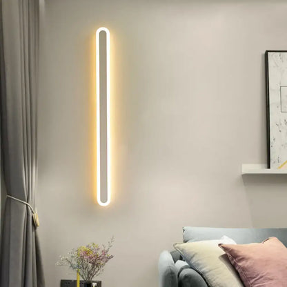 A sleek modern black and white elliptical acrylic wall sconce with warm white led strip in a minimalist oval frame