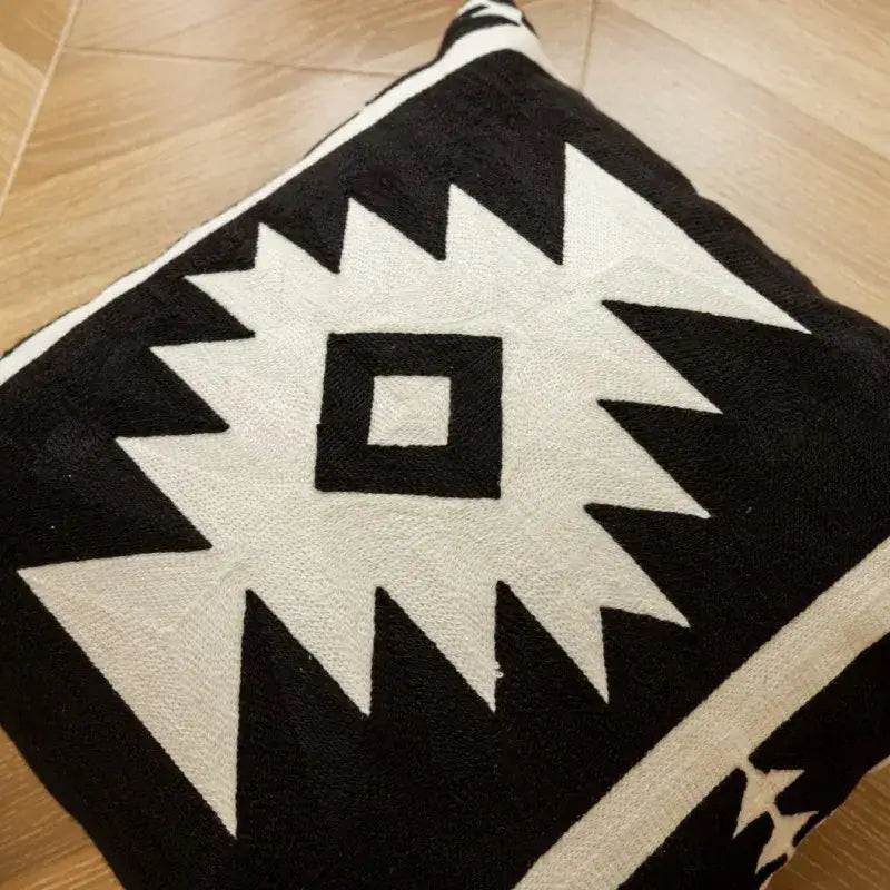 Modern black and white geometric embroidered cushion cover with bold sharp angular shapes for living room decor