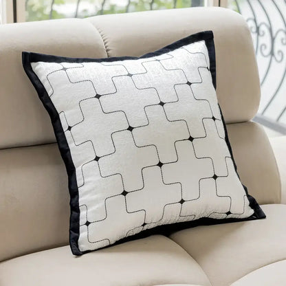 A modern black and white geometric jacquard cushion cover with black velvet border on beige sofa decorbites geometric jacquard cushion