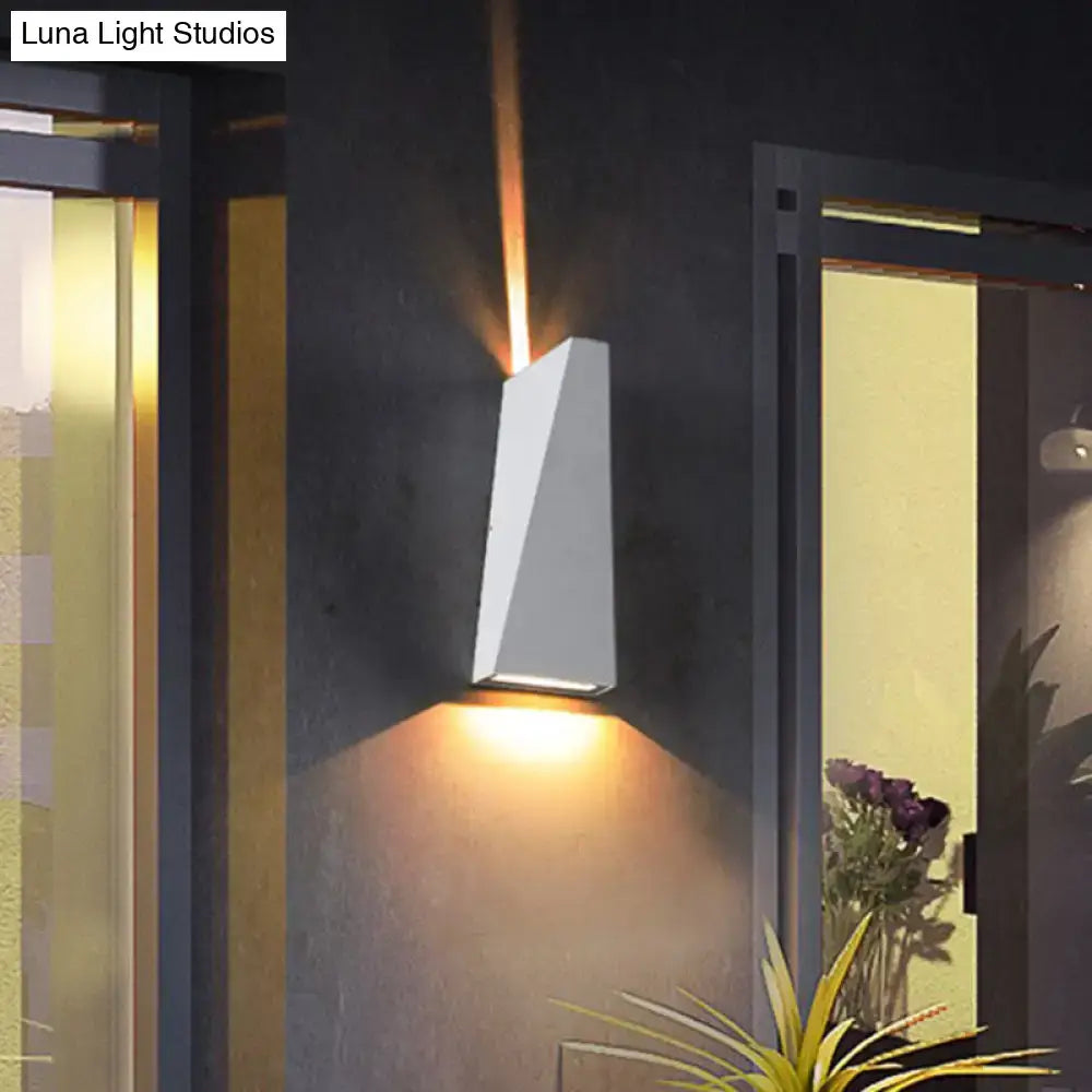 Modern black and white geometric nord wall sconce with warm amber light casting focused beams upward and downward