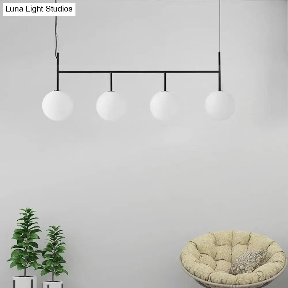 Modern black metal pendant light fixture featuring four frosted white glass orbs ideal for contemporary spaces
