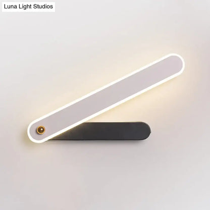 Modern black and white led wall mount fixture with sleek design and illuminated edge casting warm light for bedroom use