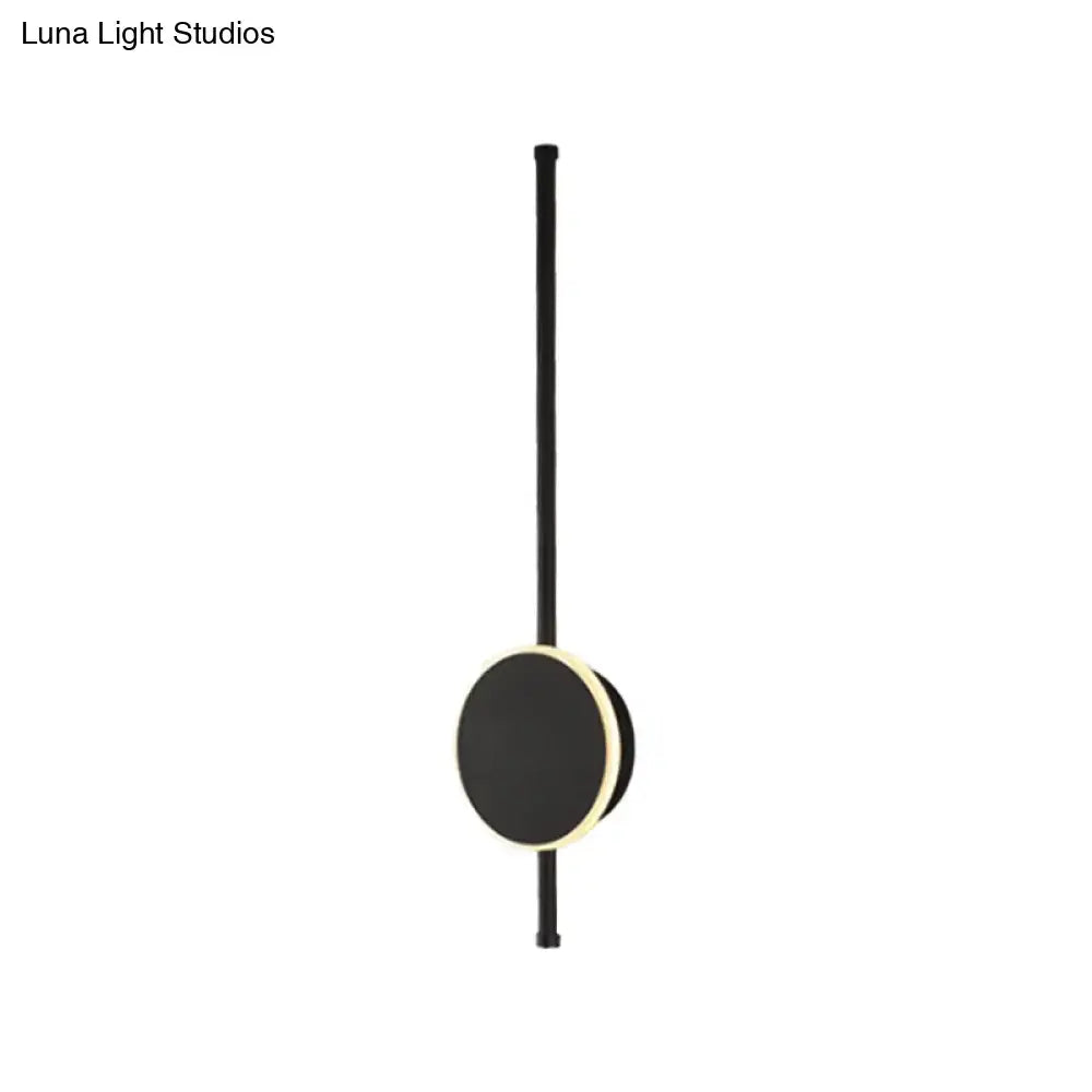 Modern black circular led wall sconce with slender stem and warm-toned accent ring for bedroom color temperature lighting