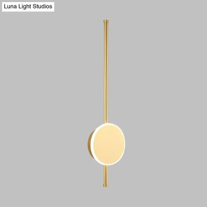 Gold-toned minimalist wall sconce with slender rod and circular light featuring warm color temperature for bedrooms