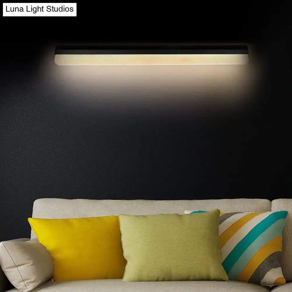 Modern black and white linear led wall light bathroom sconce emitting a warm diffused glow
