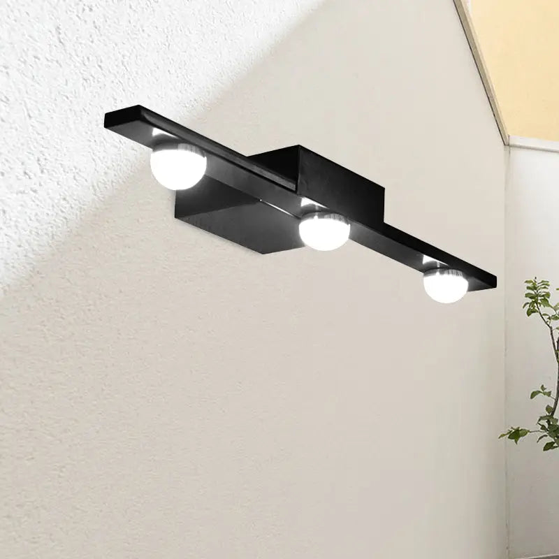 Modern black wall lighting with three spherical bulbs emitting warm white light for bathroom vanity use