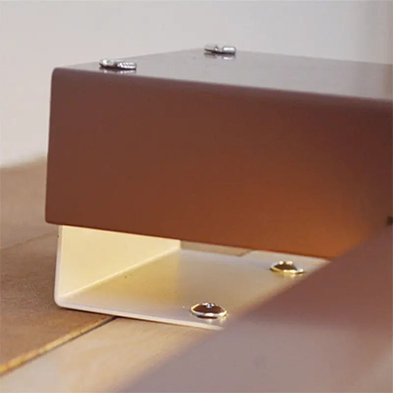 Brown rectangular magnetic base with white metal mounting bracket and silver screws for modern black white wall lighting