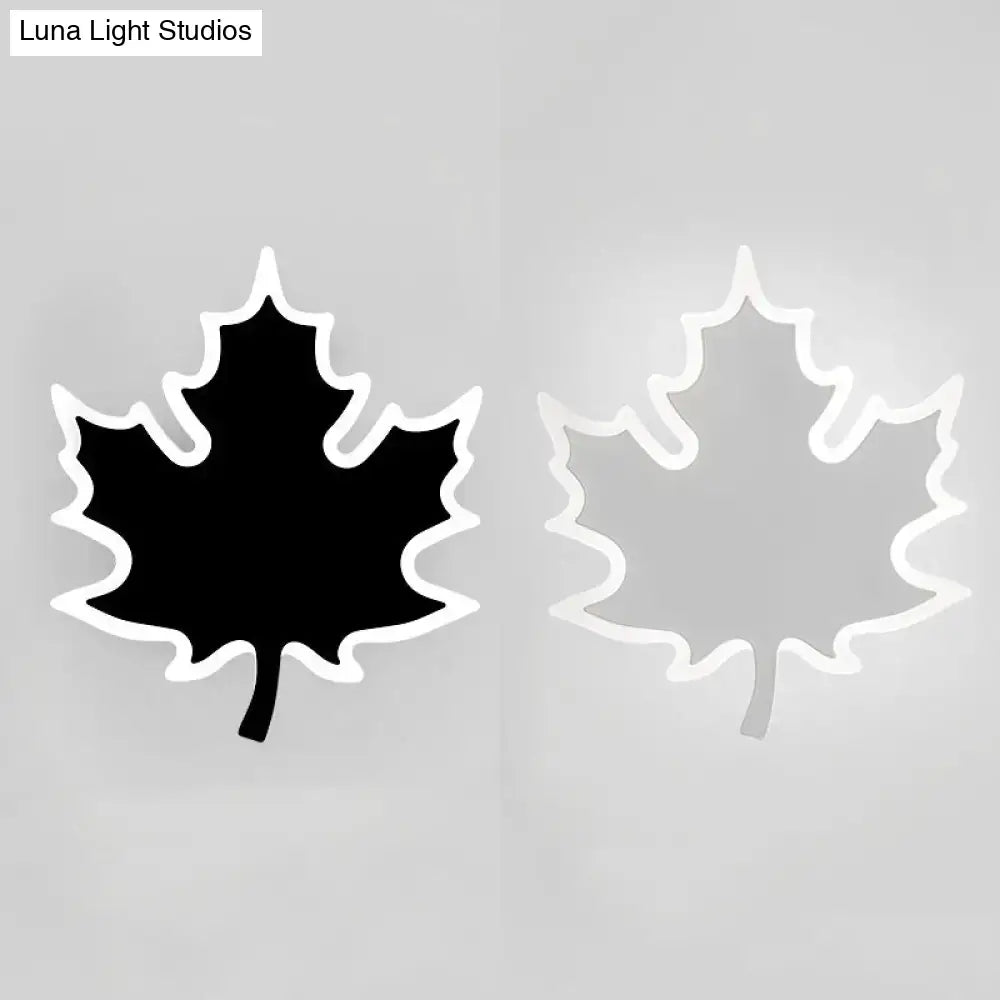 Modern black and white maple leaf sconce light with sleek white outline and illuminated black or translucent interior wall decor