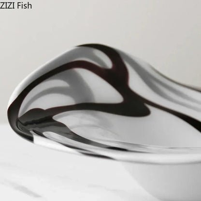 A sleek modern glass fruit plate with black and white marbled swirls designed as a dining room bowl