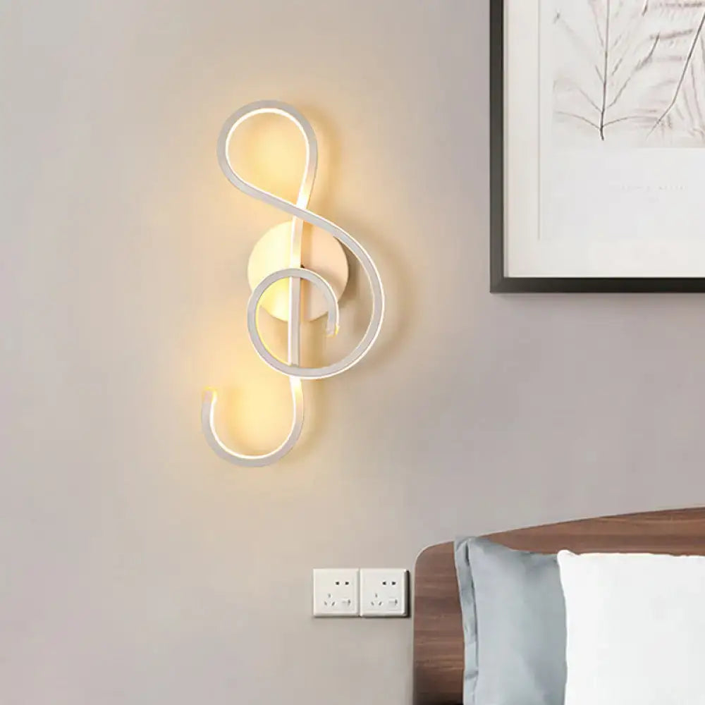 Modern black and white wall lamp shaped like a musical note with acrylic shade emitting warm ambient light