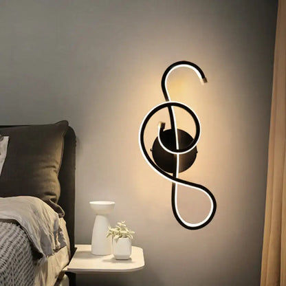 Modern black and white wall lamp shaped like a musical note with an acrylic shade for bedroom decor