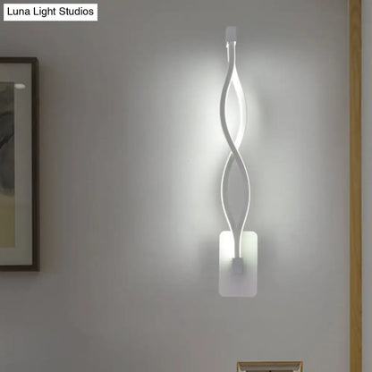 A sleek white wall lamp with a modern twisted design and acrylic shade resembling a musical note for bedroom use