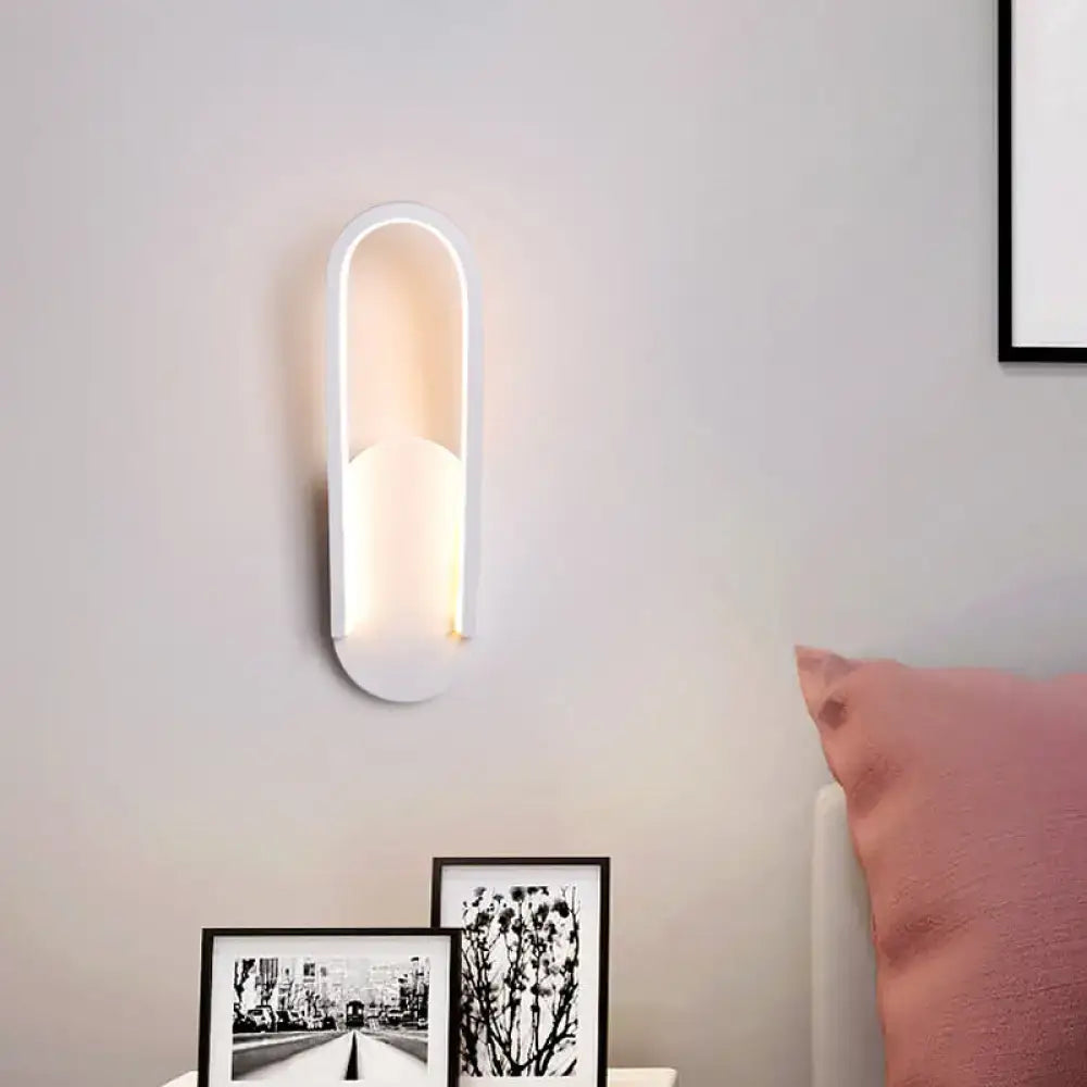 Modern black and white oval led wall sconce with warm white ambient lighting and sleek elongated oval design