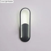 Modern black and white oval led wall sconce with a warm white color temperature and sleek minimalist design