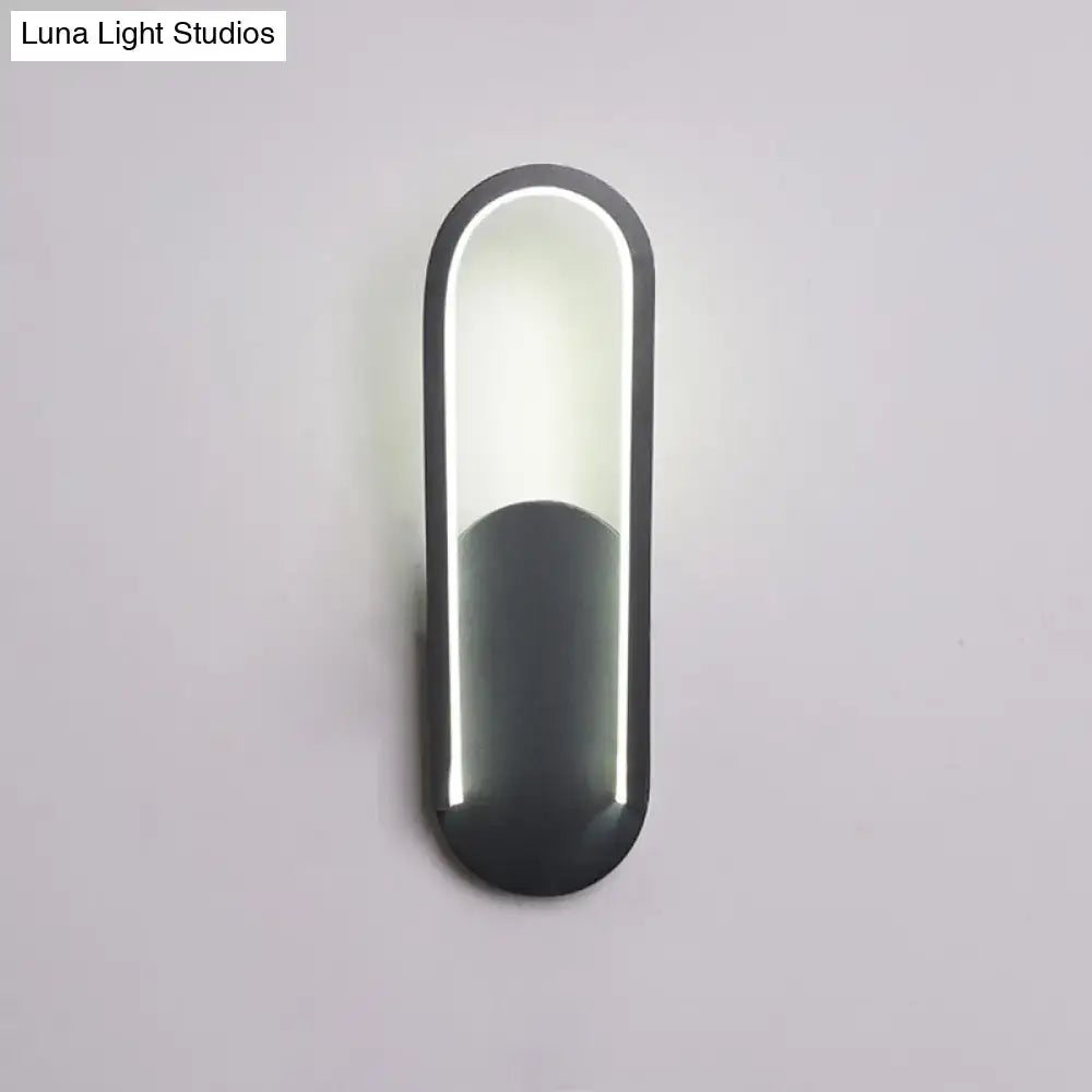 Modern black and white oval led wall sconce with a warm white color temperature and sleek minimalist design