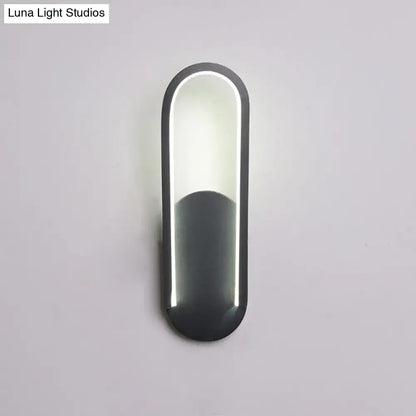 Modern black and white oval led wall sconce with a warm white color temperature and sleek minimalist design