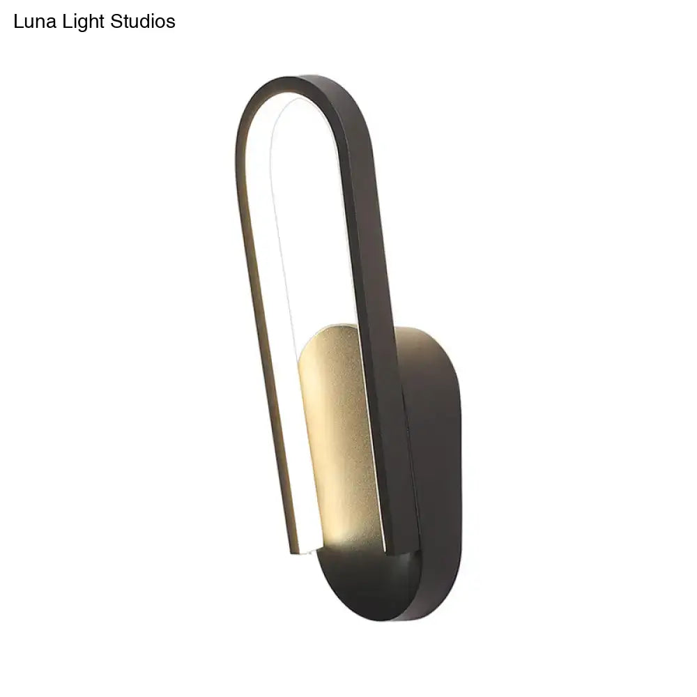 Modern black and gold accent wall sconce with sleek curved design and warm white color temperature lighting