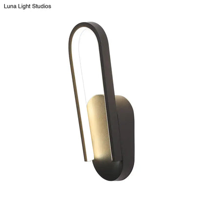 Modern black and gold accent wall sconce with sleek curved design and warm white color temperature lighting