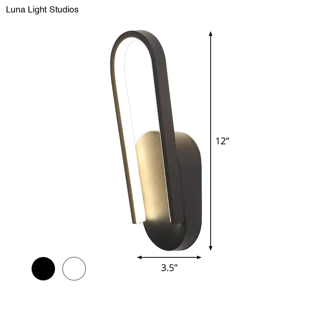 Modern black and gold accent wall sconce with sleek curved design featuring warm white color temperature lighting