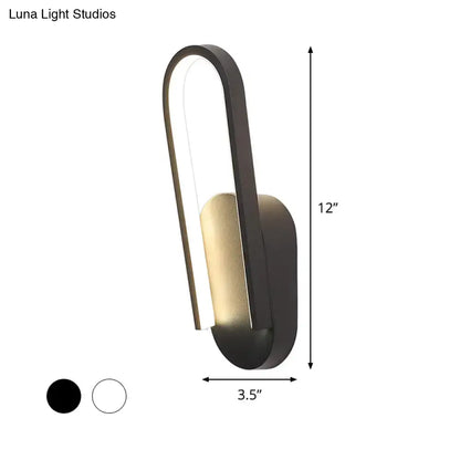 Modern black and gold accent wall sconce with sleek curved design featuring warm white color temperature lighting
