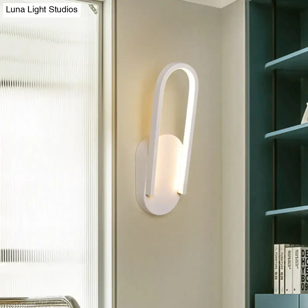 Modern black and white oval led wall sconce with warm white color temperature and sleek curved minimalist design