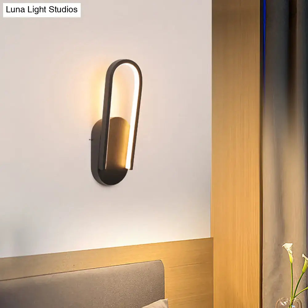 Modern black and white oval led wall sconce with sleek curved design and warm white color temperature lighting