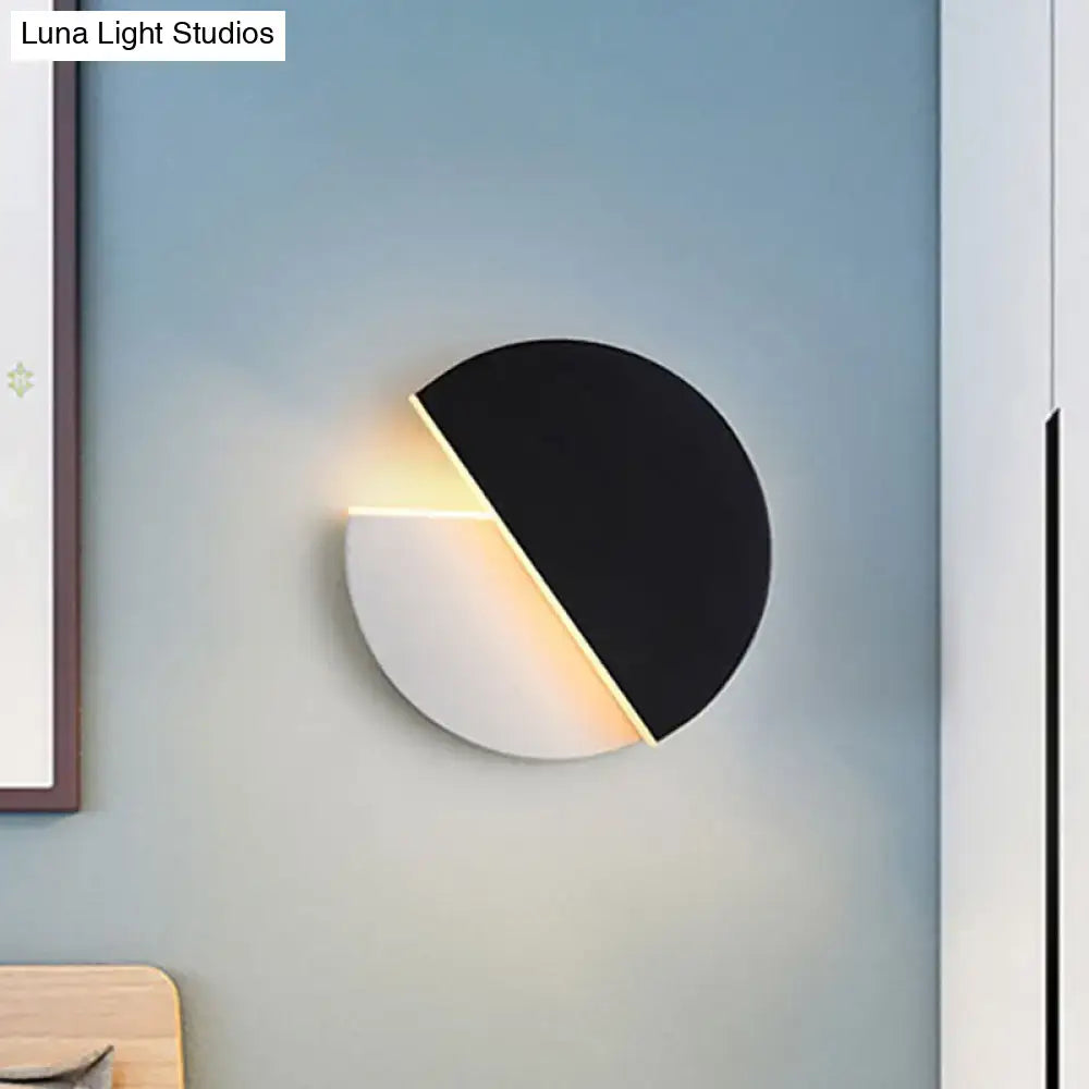 Modern black and white acrylic wall lamp with a rotatable half-circle design emitting warm ambient light