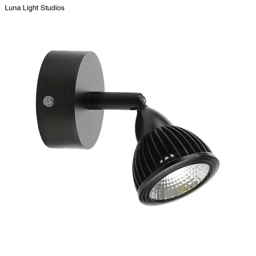 Modern black and white wall light with matte black ribbed adjustable spotlight and sleek cylindrical base for bedroom use