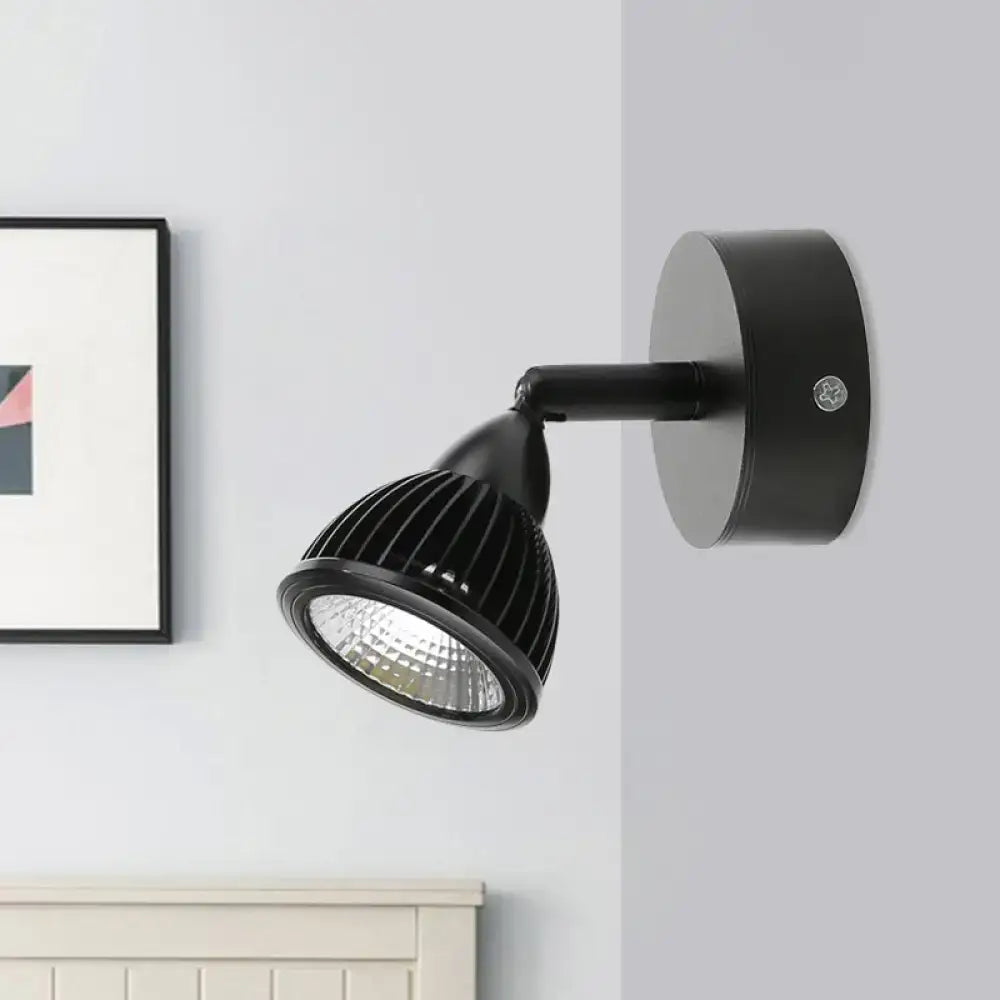 Modern black and white rotatable wall light with a ribbed matte housing and circular base for bedroom spotlight use