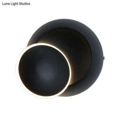 Modern black matte wall lamp with white rotating eclipse design and illuminated ring accent for bedroom use