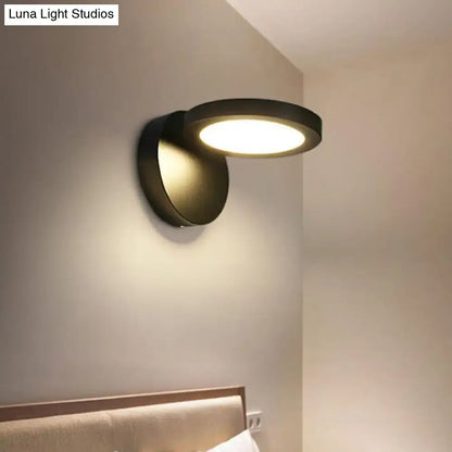 Modern black circular wall light fixture with sleek minimalist design and warm ambient glow for bedroom use