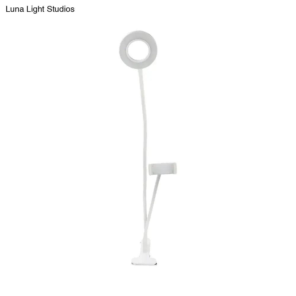 White flexible round usb mirror lamp with black clip base and phone holder for modern bedroom use
