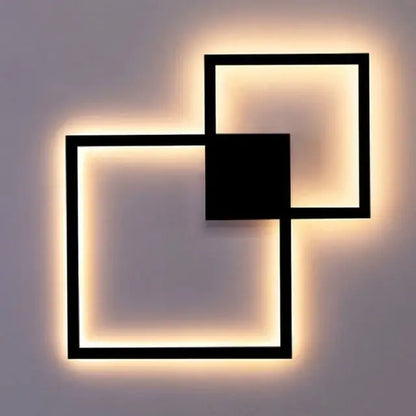 Modern black and white square led wall sconce with warm glowing light for bedroom lighting and decor