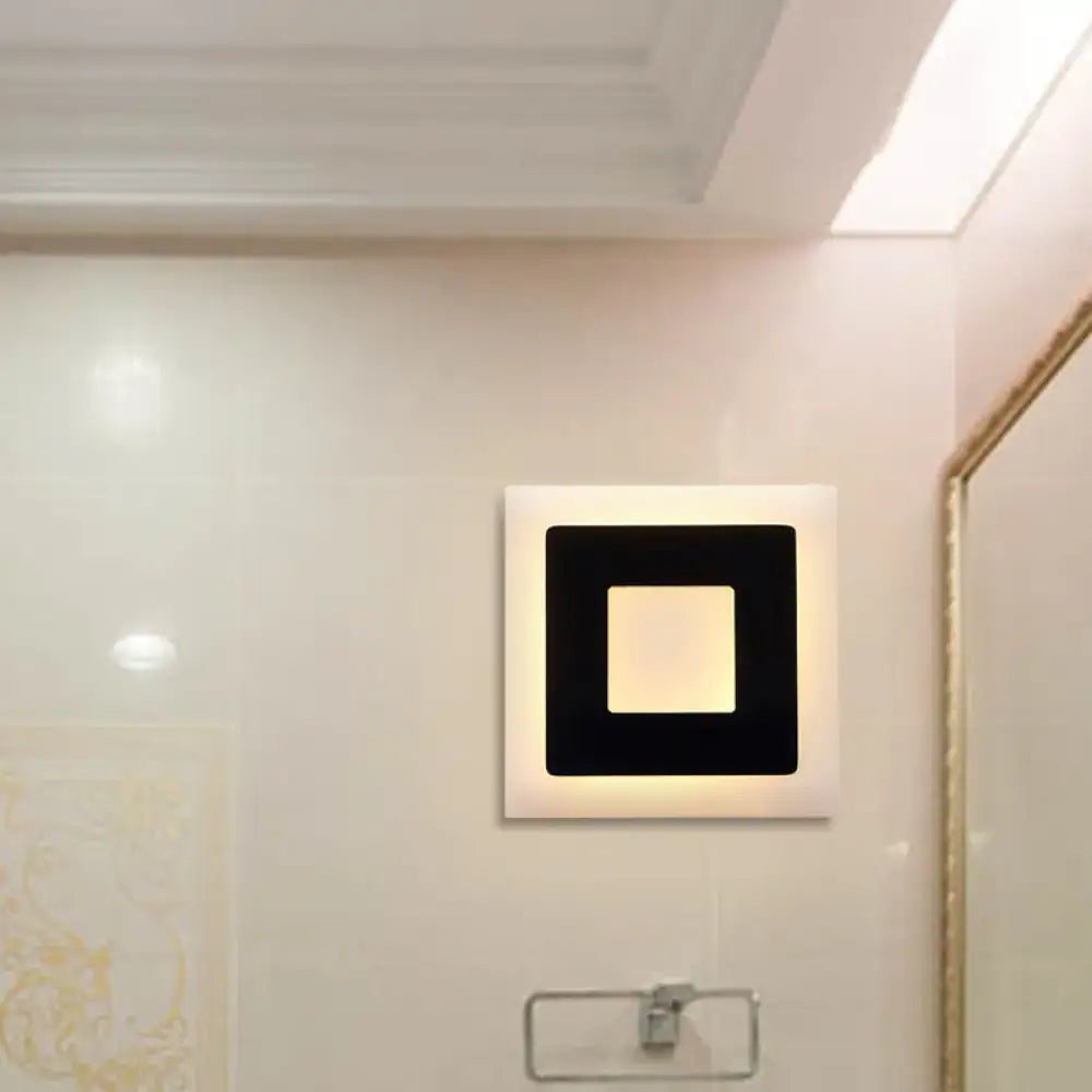 Modern black and white square wall sconce lamp with sleek white frame and warm glowing center for bedroom lighting