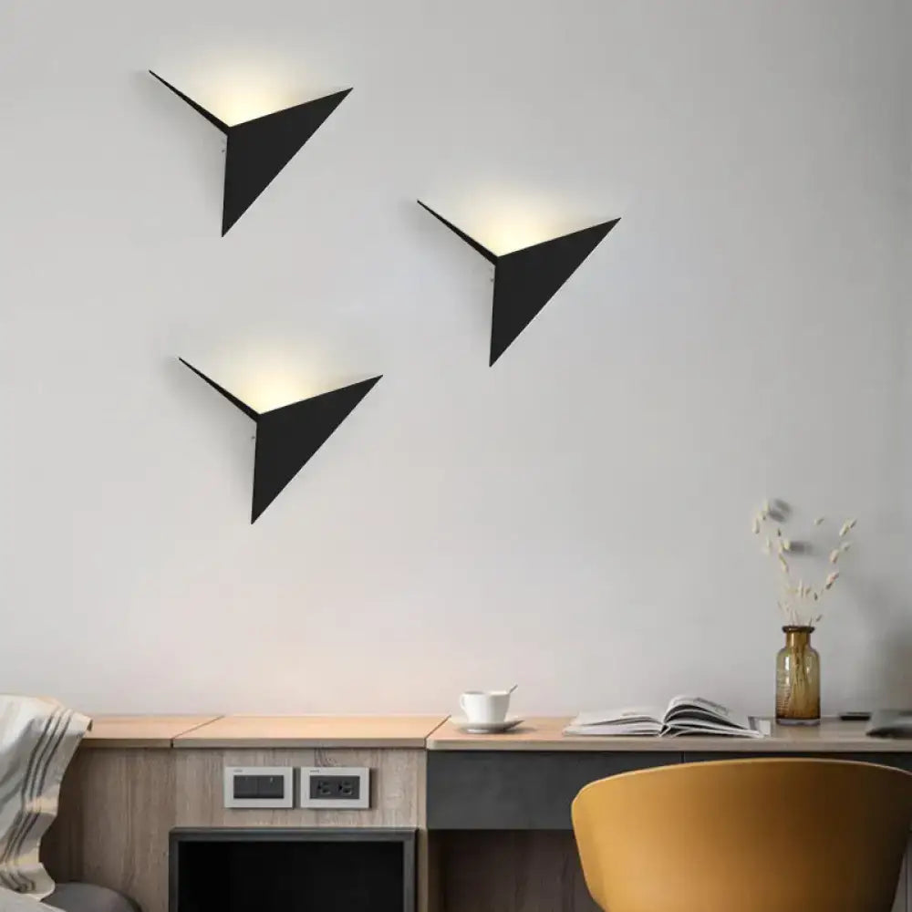 Three sleek black triangle sheet wall lamps with warm angled lighting for modern bedroom wall lamp use