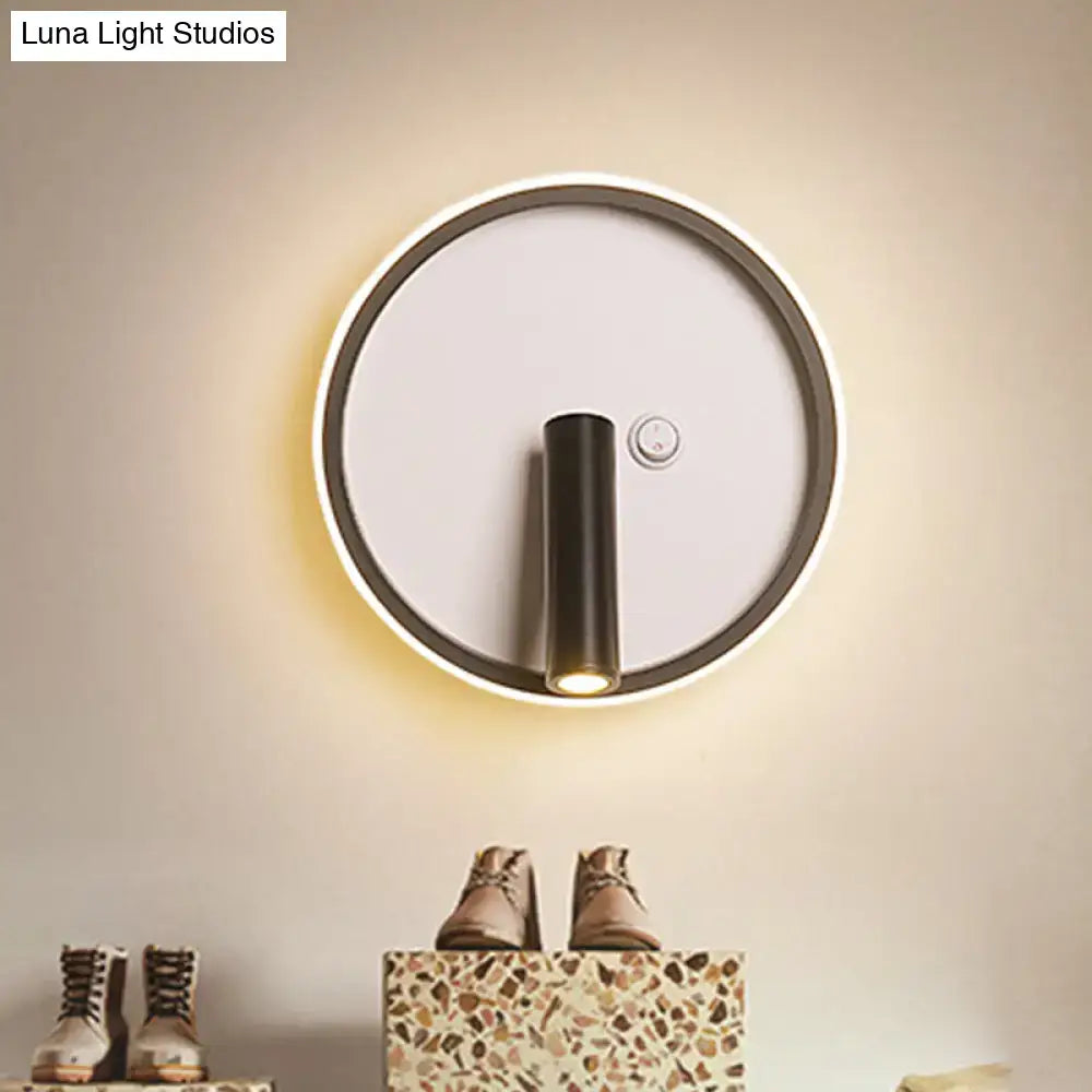 Modern black and white warm light wall sconce with sleek cylindrical fixture and white warm light ring for bedroom use