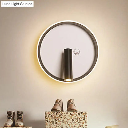 Modern black and white warm light wall sconce with sleek cylindrical fixture and white warm light ring for bedroom use