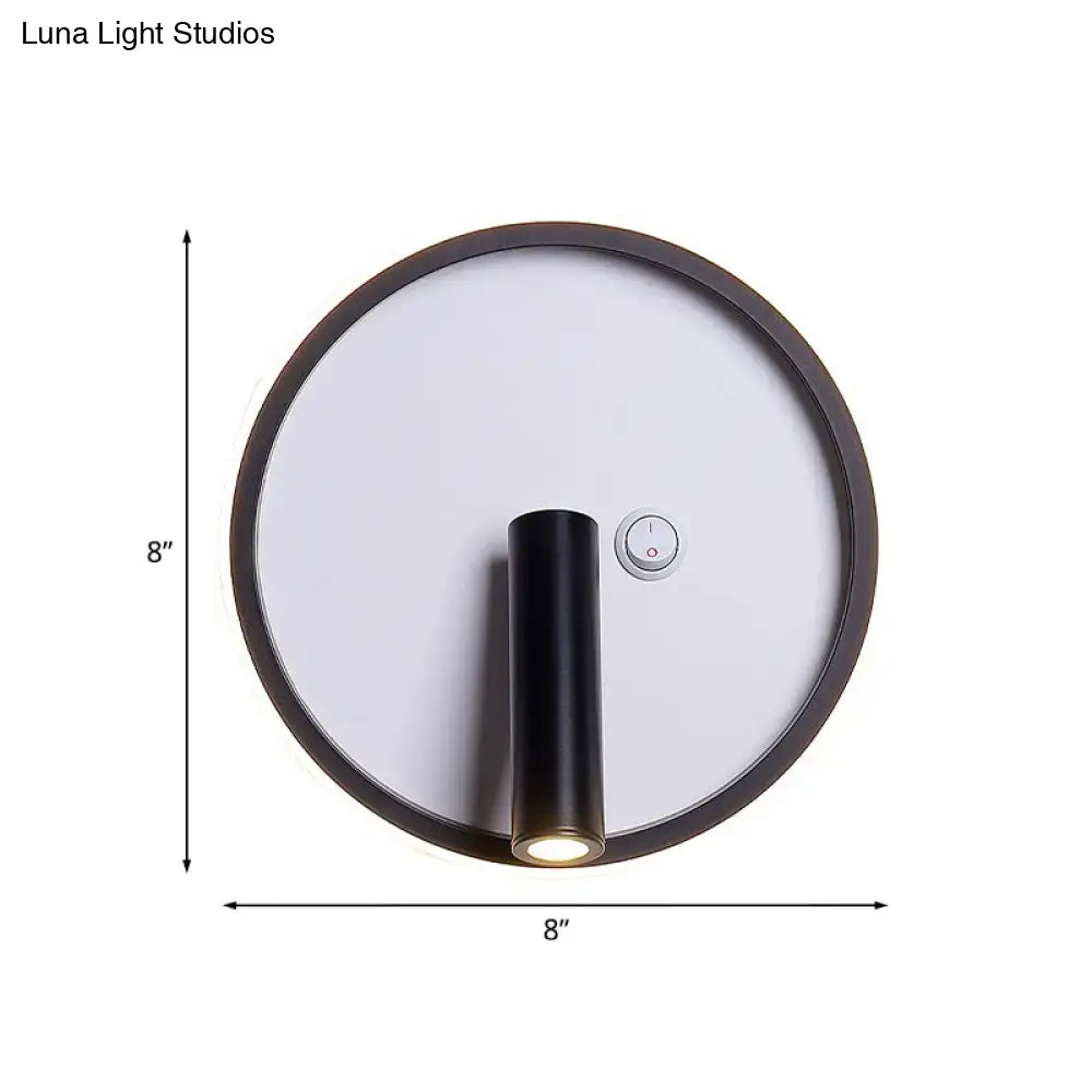 Modern black and white warm light wall sconce with 8-inch diameter cylindrical fixture emitting white warm light