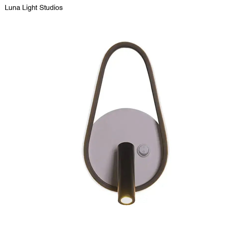 Modern wall light with sleek curved dark bronze frame and circular silver base emitting white warm light ideal for bedroom use