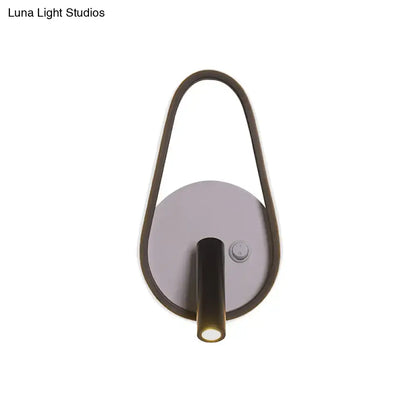 Modern wall light with sleek curved dark bronze frame and circular silver base emitting white warm light ideal for bedroom use
