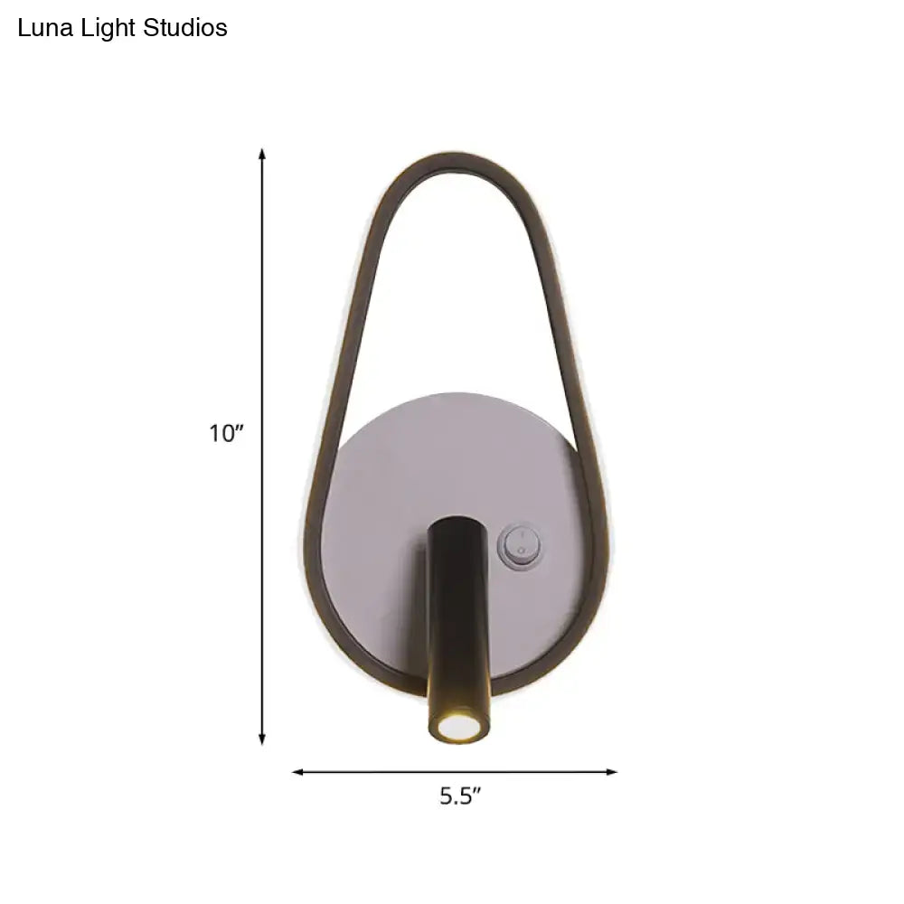 Modern wall light with sleek curved dark bronze frame and circular silver base emitting white warm light for bedroom use